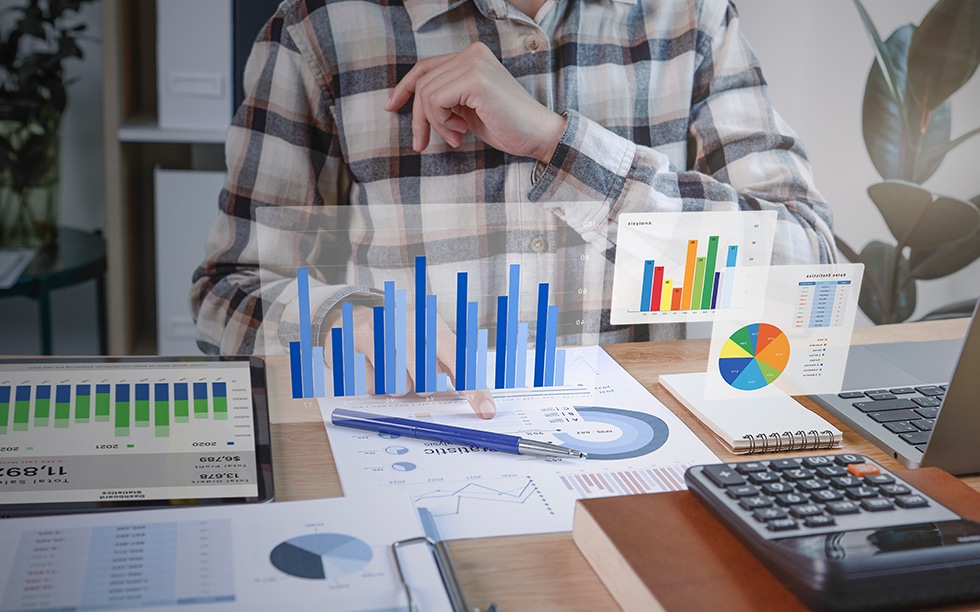 Person doing work at desk with 3D visualization of graphs